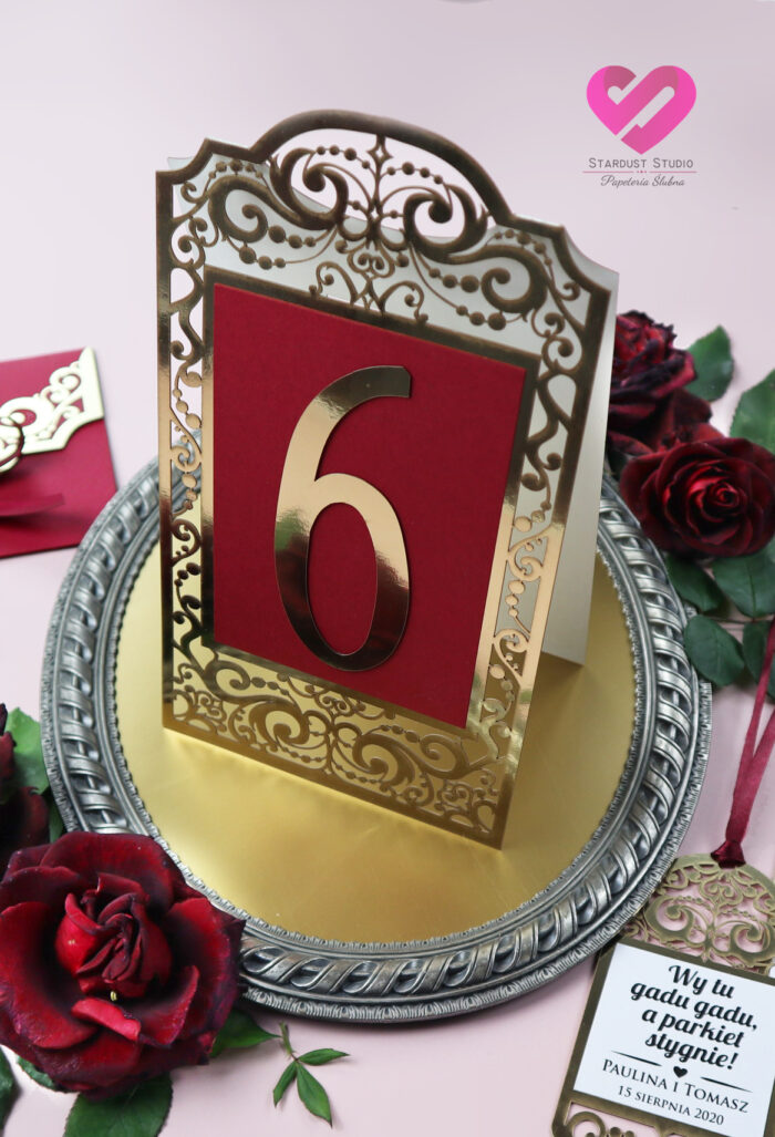 Oryginalne, ażurowe numery stołów na stół weselny w kolorze złota i bordo w stylu glamour. Kolekcja Royal.