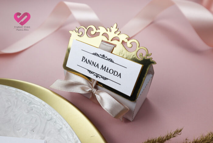 Pastelowe, romantyczne winietki ślubne pudełeczka w stylu glamour z delikatną różową wstążką i złotym ażurem pasujące do zaproszeń. Podziękowania dla gości.